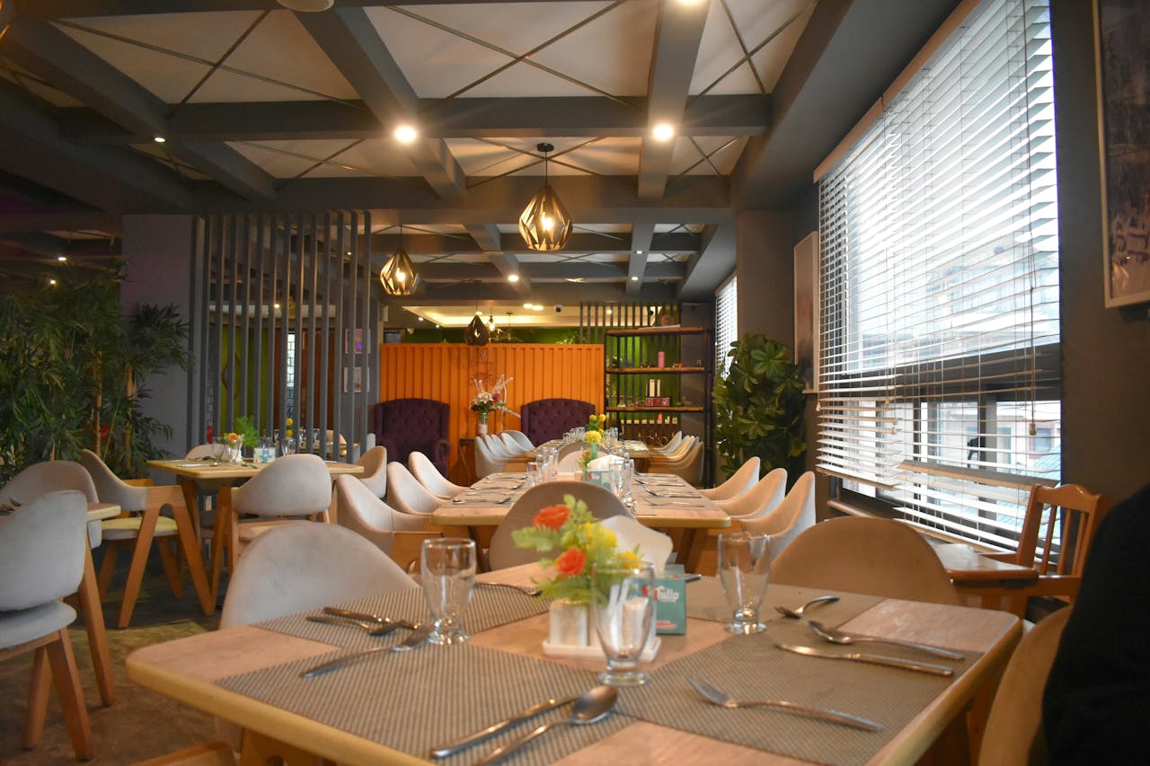 gallery-03 A warm and stylish restaurant interior featuring elegant wooden tables and cozy seating under ambient lighting.